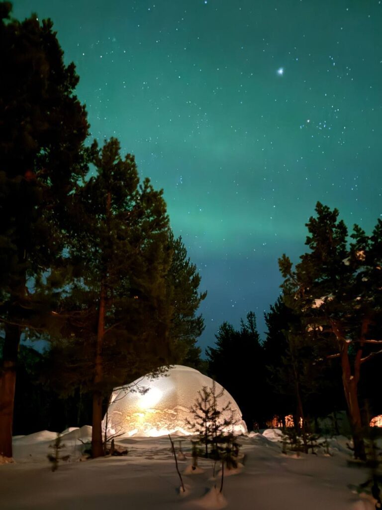northern lights over glass igloo in Alta, Norway